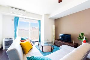 a living room with a white couch and a television at FANCY in Sapporo
