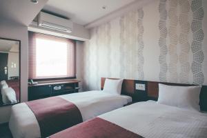 En eller flere senge i et værelse på Hotel Kuretakeso Takayama Ekimae