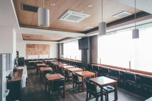 una sala da pranzo con tavoli e sedie in legno di Hotel Kuretakeso Takayama Ekimae a Takayama
