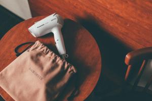 a hair dryer on a wooden table next to a bag at Hotel Kuretakeso Takayama Ekimae in Takayama