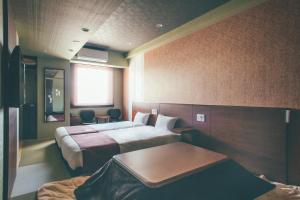 En eller flere senge i et værelse på Hotel Kuretakeso Takayama Ekimae