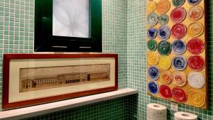 een badkamer met een ingelijste foto van een gebouw aan de muur bij La Maison de Fuecopared in Florence +30 foto's