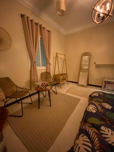 een slaapkamer met een bed, een tafel en een raam bij Bohemian style in Abha