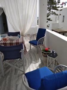 balcón con sillas azules, mesa y mesa en Kiki's apartment huge balcony dream, en Chrissi Akti