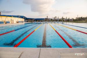 una grande piscina con corsie blu e rosse di Pattana Sports Resort a Si Racha