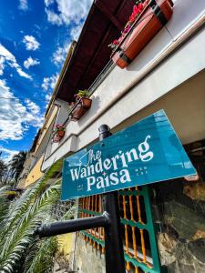 a blue street sign in front of a building at The Wandering Paisa in Medellín