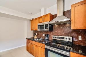 a kitchen with wooden cabinets and a stove top oven at The Philly place to stay! 2BD apartment steps from the Convention Center in Philadelphia