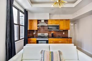 a living room with a white couch in front of a kitchen at Classic Modern with a splash of Glam 2BD Apt in Philadelphia