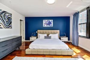 a bedroom with blue walls and a large bed at Classic Modern with a splash of Glam 2BD Apt in Philadelphia