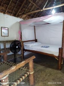 Zimmer mit 2 Etagenbetten und einem Ventilator in der Unterkunft Mida Creek Eco Camp - relax in cosy cottage in Mida