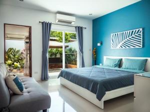 een blauwe slaapkamer met een bed en een bank bij Aonang Symphony 3 Bedrooms Private Pool Villas in Ao Nang Beach +12 foto's