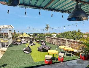 a patio with some tables and some lights and grass at Lushy Hostel Canggu in Canggu