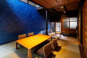 uma sala de jantar com uma mesa de madeira e cadeiras em YADORU KYOTO HANARE Mizunoe No Yado em Quioto