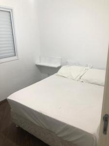 białe łóżko w białym pokoju z oknem w obiekcie Apartamento bem Localizado w São Paulo