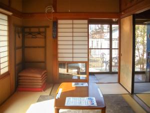 una camera con tavolo e porta di accesso a un patio di guest house AN a Otsu