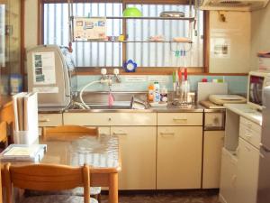 a small kitchen with a sink and a table at guest house AN in Otsu