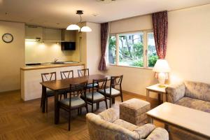 a living room with a table and chairs and a kitchen at Luxze Hitotsuba/Cottage Himuka in Miyazaki