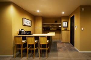 a kitchen with a bar with chairs and a counter at Onsen no yado Gion Maisen Bettei in Kyoto