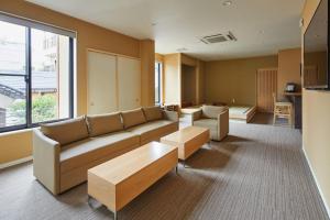 a living room with a couch and a table at Onsen no yado Gion Maisen Bettei in Kyoto +10 photos
