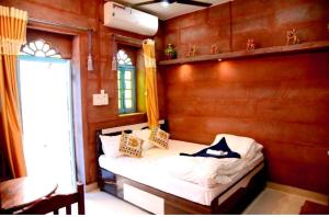 ジョードプルにあるMH Guest Houseの木製の壁のベッドルーム1室(ベッド1台付)