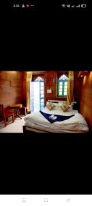 a bedroom with a large bed and a table at MH Guest House in Jodhpur