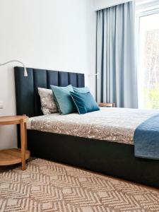 a bedroom with a bed with blue pillows on it at Apartment 1007 Rogowo Pearl in Mrzeżyno