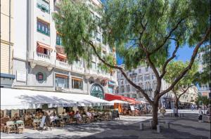 uma representação de uma rua com pessoas sentadas às mesas em Studio Magenta em Nice