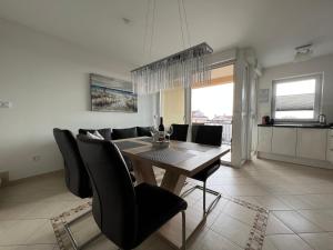 a dining room with a wooden table and black chairs at Maj Premium Apartment 4 Sterne - neu renoviert in Poreč