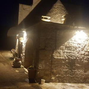 un edificio de piedra con luces encendidas por la noche en Il Trullo di Nonna Lella, en Castellana Grotte