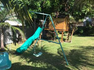 a playground with a green slide in a yard at Manapescale in Saint-Joseph