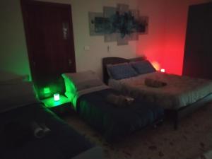 twee bedden in een kamer met groen en rood licht bij All inBasilicata Bed & Breakfast in Baragiano