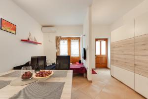 a living room with a table with a bowl of fruit at Piran Punta Beach Apartment in Piran