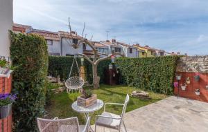 a backyard with a table and chairs and a fence at Apartments Ariana in Umag