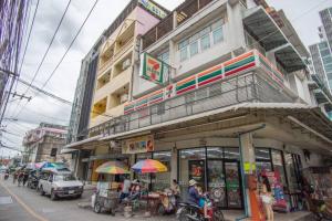 T4 Two Bedrooms Full kitchen/1 min to BTS في بانكوك: مبنى فيه ناس جالسين خارجه على شارع المدينة