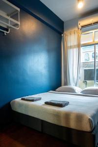 T4 Two Bedrooms Full kitchen/1 min to BTS في بانكوك: غرفة زرقاء مع سرير عليها منشفتين
