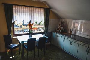 une cuisine avec une table et des chaises ainsi qu'une fenêtre dans l'établissement Apartmaji Krebs, à Mežica