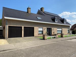 een huis met twee garagedeuren in een straat bij Maison de Marcel Big house near centre free parking in Brugge