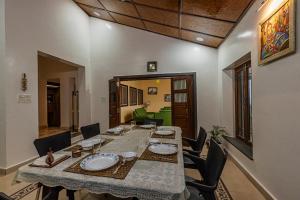 a dining room with a long table and chairs at SaffronStays Verandah by the Valley, Panchgani - luxury villa and treehouse with beautiful valley and lake views in Panchgani +32 photos