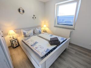 1 dormitorio con 1 cama blanca y ventana en Ferienhaus Sellin, en Ostseebad Sellin