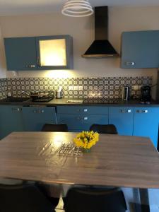 a kitchen with a wooden table with yellow flowers on it at Gerardmer : Residence "l'eau vive" in Gérardmer