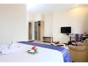 una habitación de hotel con una cama con una flor. en Rio City Hotel, en Palembang