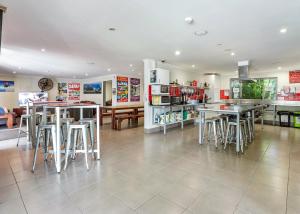 un restaurante con mesas y taburetes en una habitación en Noosa Flashpackers, en Sunshine Beach