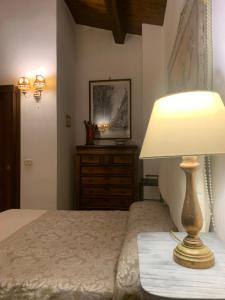een slaapkamer met een bed met een lamp en een dressoir bij Suite alla Cattedrale in Palermo