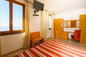a bedroom with a bed and a desk and a window at Albergo Luna di Marzo in Volastra