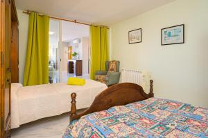 a bedroom with two beds and a chair at Casa Meli in Finestrat