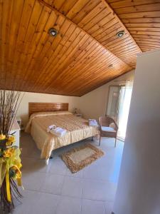 a bedroom with a bed and a wooden ceiling at Villa Grazia in Fondachello