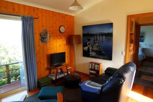 een woonkamer met een bank en een televisie bij 19 Blue in Kingston Beach