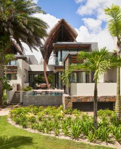 uma casa com piscina e palmeiras em LUX* Grand Baie Resort & Residences em Grand Baie