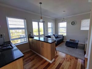 a kitchen and living room with a couch and a table at 19 Malachite Mews in Knysna