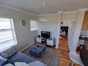 a living room with a blue couch and a tv at 19 Malachite Mews in Knysna